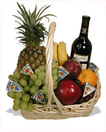 Fruit basket with pineapple, grapes, bananas, apples, and a wine bottle