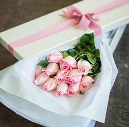 Bouquet of pale pink roses wrapped in white paper