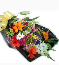 Mixed bouquet of colorful flowers wrapped in black paper with a yellow bow