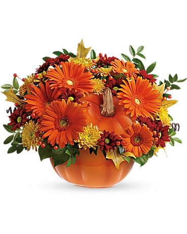Orange pumpkin centerpiece with orange and yellow flowers