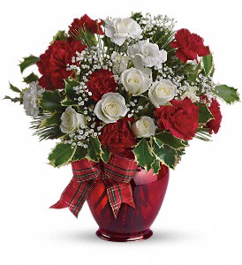 Red and white floral arrangement in a red vase with a plaid ribbon