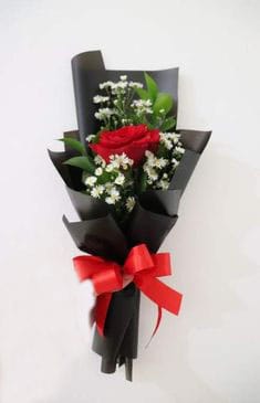 Red rose bouquet with white filler flowers wrapped in black paper and tied with a red bow