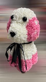 Pink and white rose arrangement shaped like a dog with a black ribbon