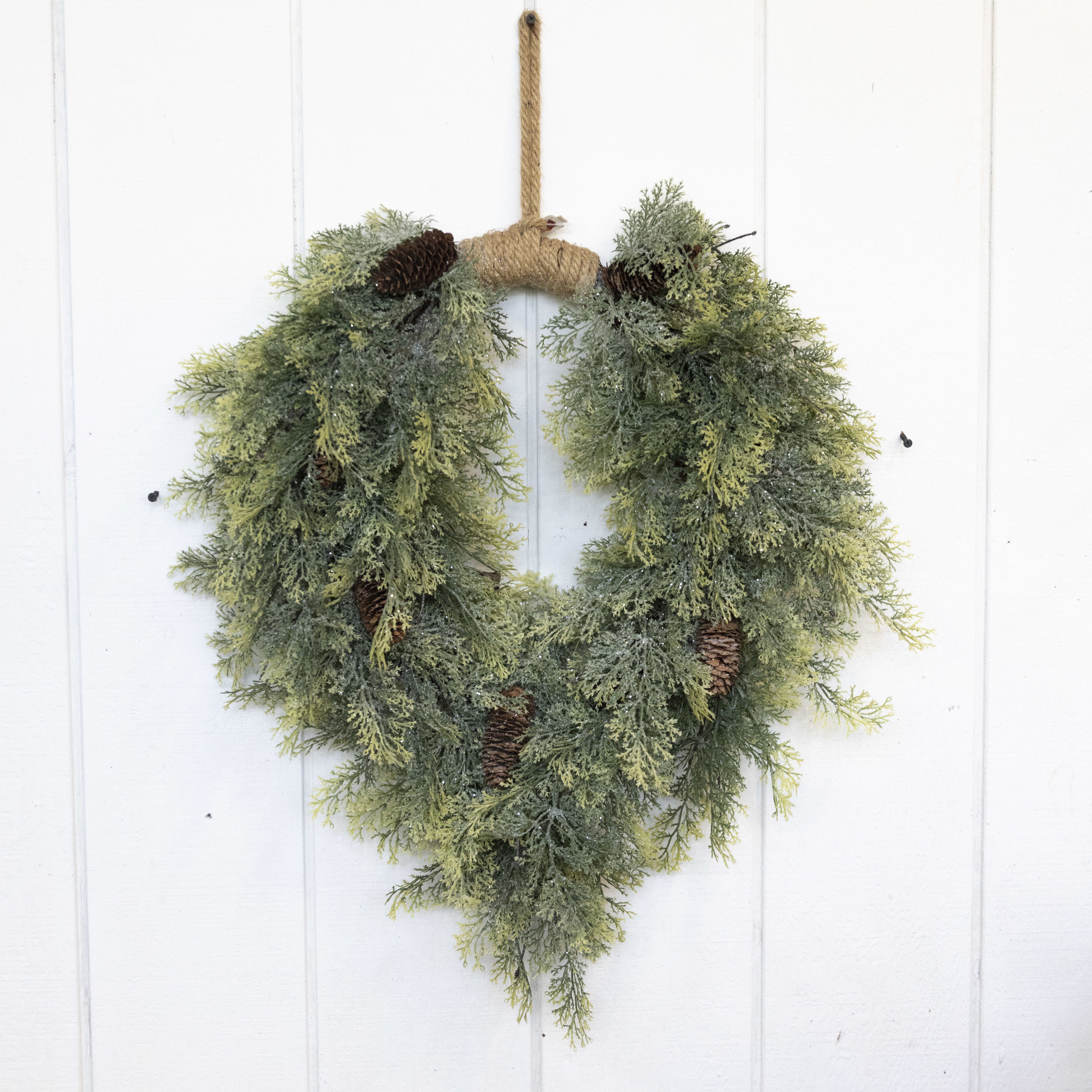 Heart-shaped evergreen wreath with pinecones and rope hanger