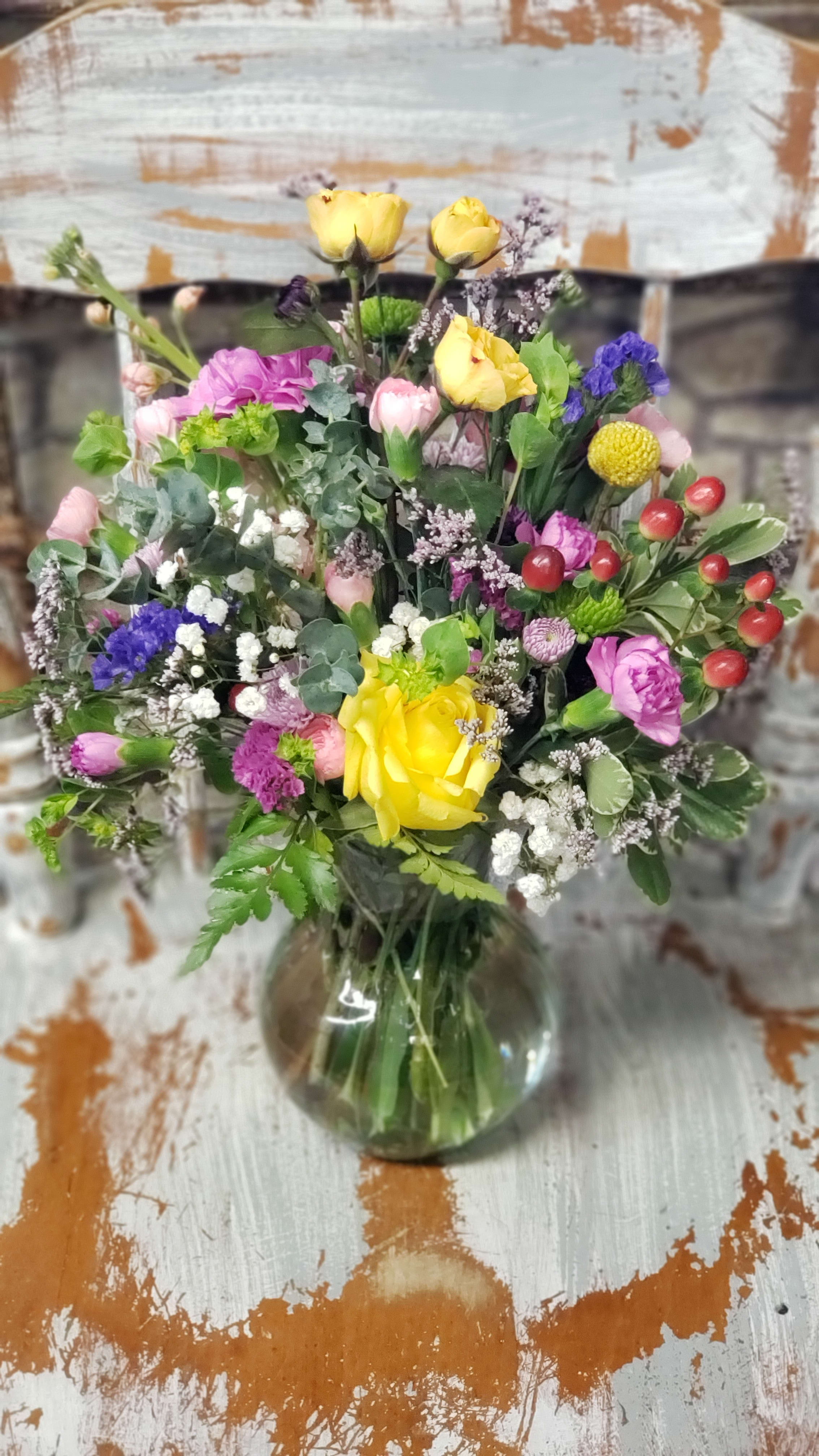 Sweeter with color  -  Classic circular style in a glass vase. Loads of color and texture. Designer will choose a variety of colors and flowers based on market fresh selection at time of order and delivery. Photo sample is for style and size only!