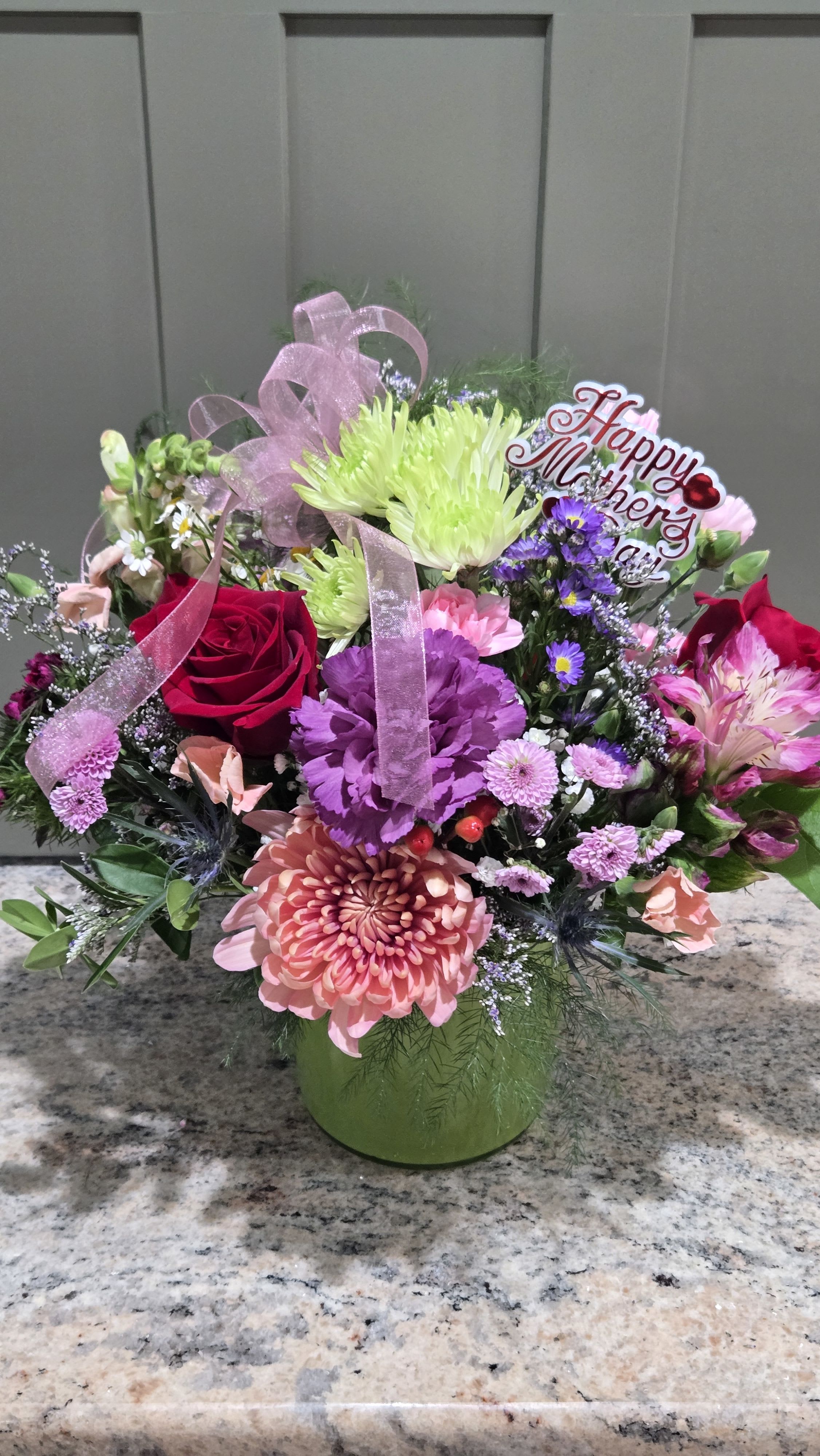 Mixed bouquet in a green vase with a Happy Mother's Day sign