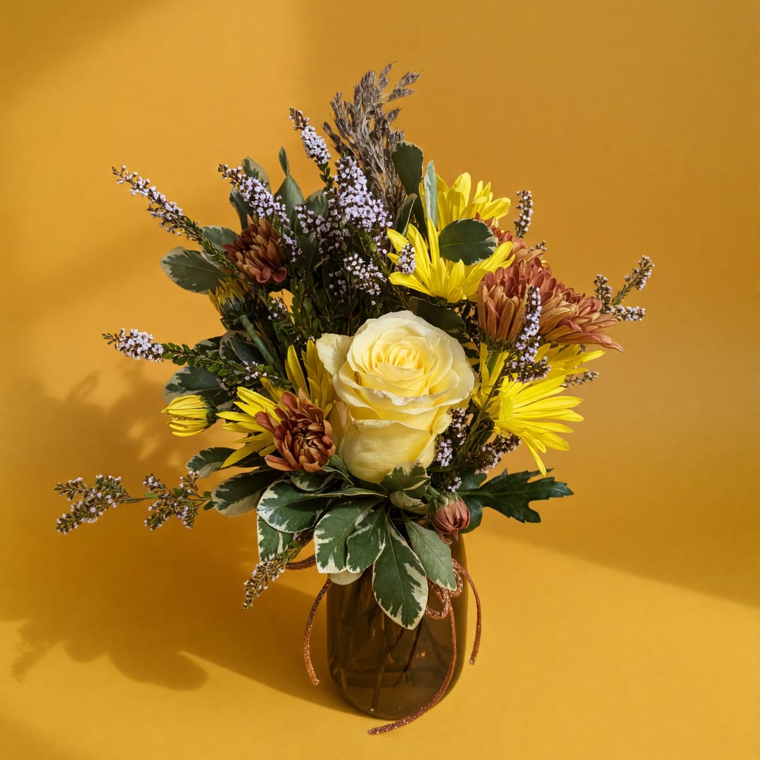 Yellow and brown mixed bouquet in a glass vase