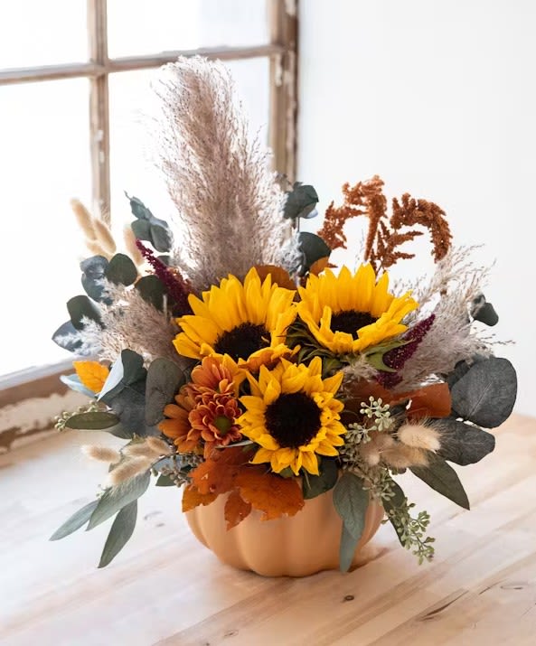Harvest - This trendy fall mix of dried and fresh flowers arrangement will last for weeks and will for certain be the talk of your next gathering. Made in a ceramic pumpkin with sunflowers, fall daisy poms, dried greenery and other dried/ preserved flowers.