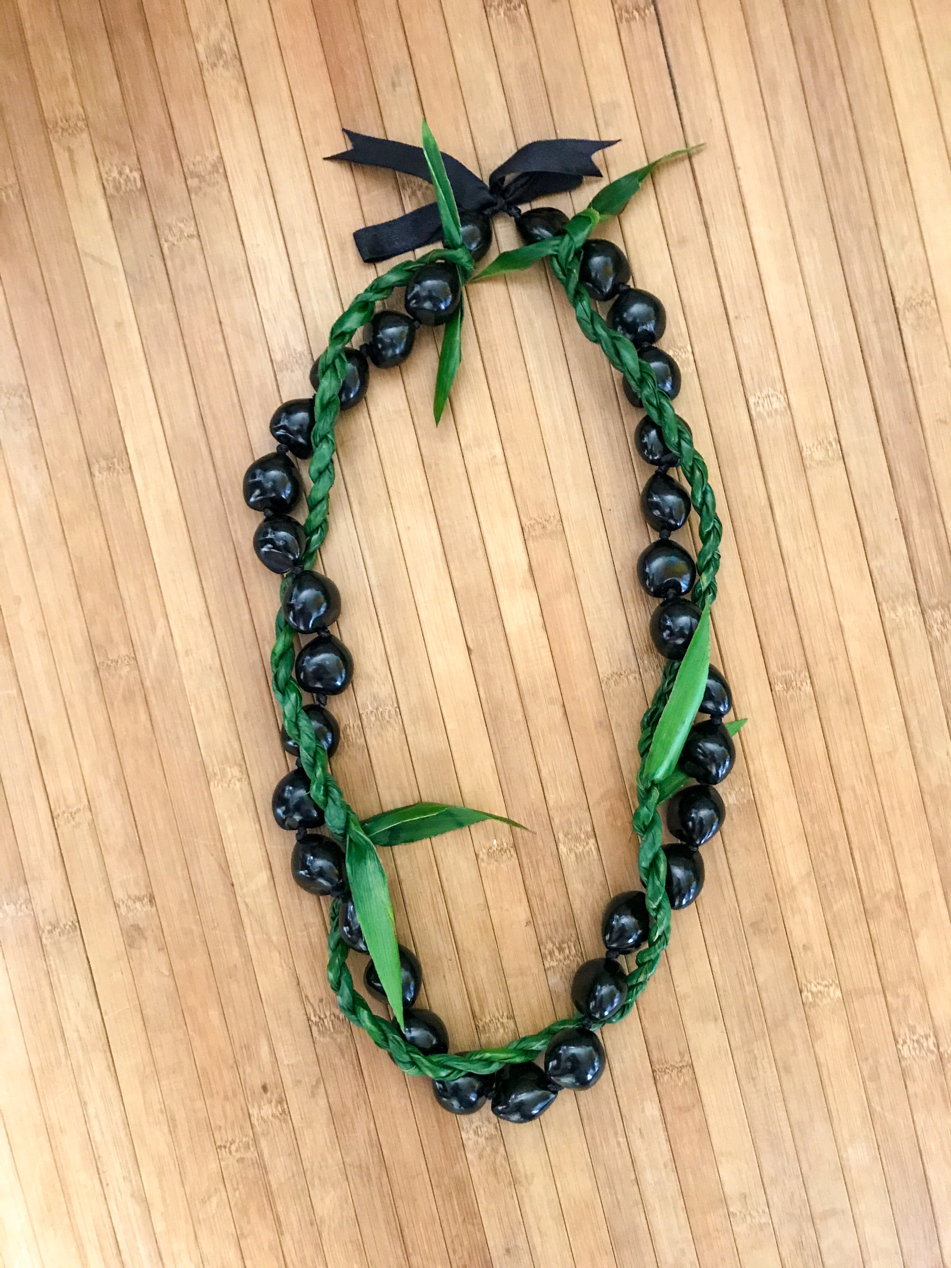Maui - Kukui Nut lei wrapped with a thin ti leaf lei is a great lei to give a loved one who would love something simple. 