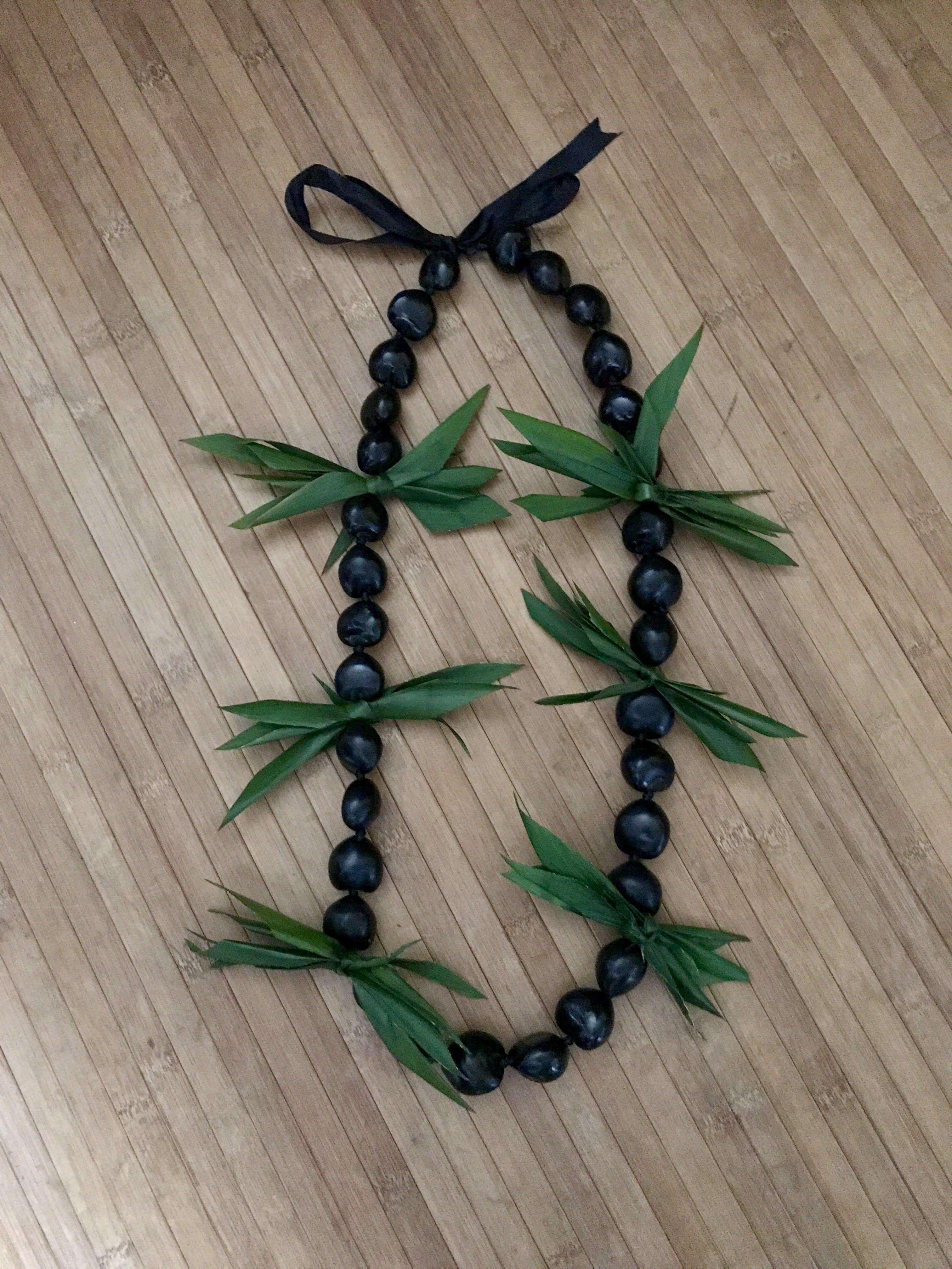 Kukui Nut lei with ti leaf - Kukui nut lei with bursts of ti leaves.  PLEASE ORDER AT LEAST 2 DAYS IN ADVANCE. 