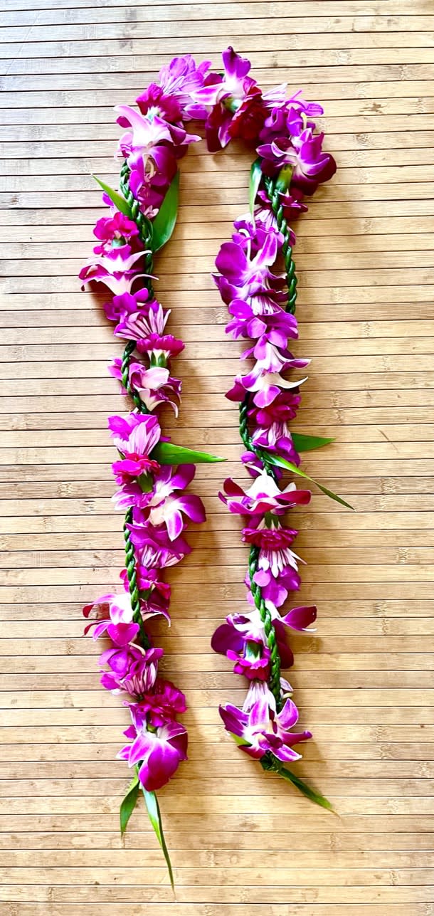 Kui purple flower lei with ti leaf lei wrap - Great for all occasions! This beautiful open ended purple flower lei with ti leaf wrap has a wonderful mix of orchids, mums, mini carnations wrapped with a ti leaf lei.  PLEASE NOTE: if you would like in a different color pallet. If your recipient is below 5' tall or taller than 6' so we can make the lei appropriate length for them. Also please let us know the dimensions if being used on a table or picture frame. Thank you! 