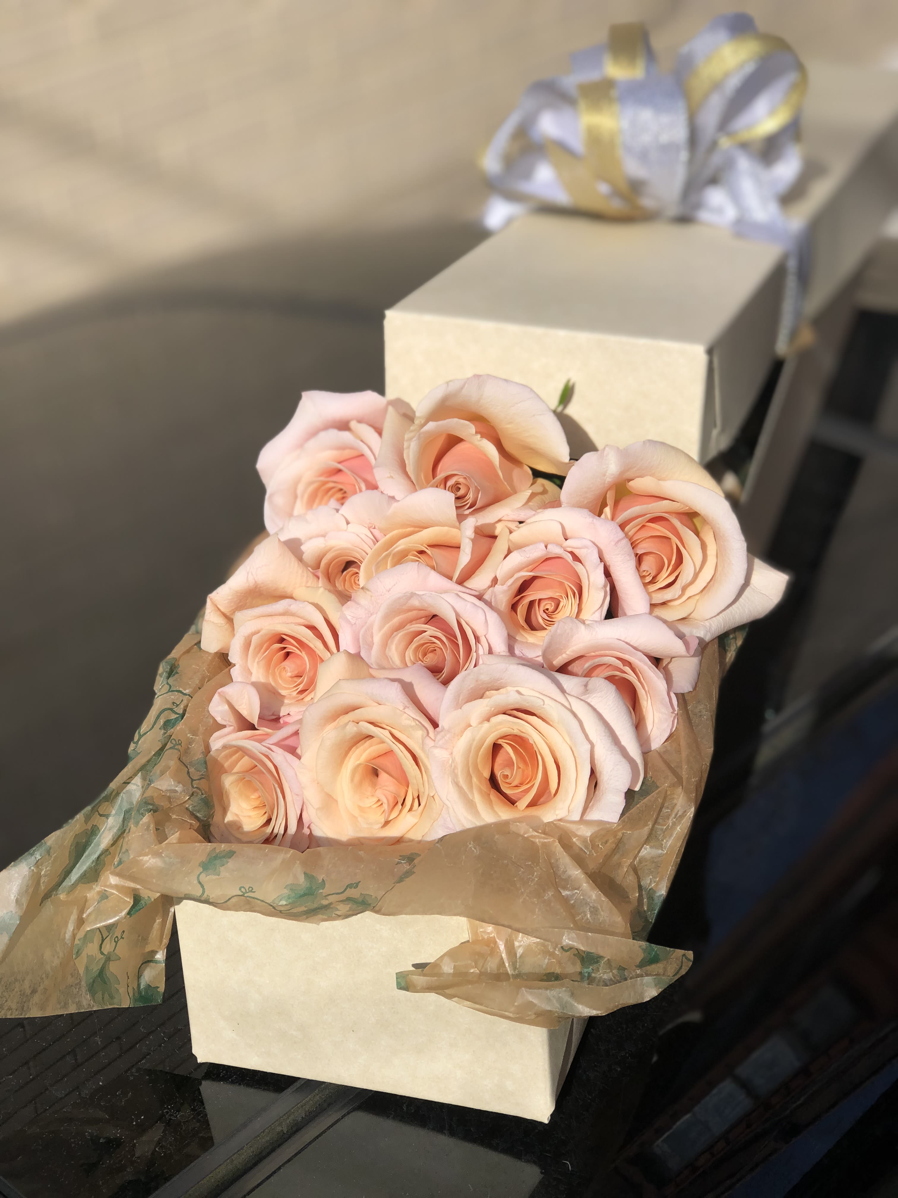 Bouquet of pale peach roses wrapped in brown paper