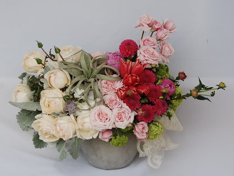 Secret Garden  - A unique assortment of garden roses, dahlias, tulips, peonies and viburnum in gray concrete container with a beautiful large xerographica air plant and silver dusty miller accents.  