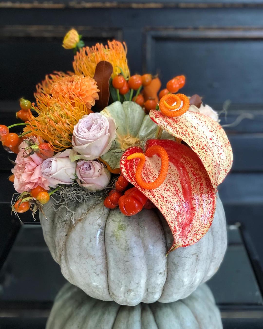Orange Splash Pumpkin  - Fresh carved pumpkin arrangement with exotic twist.  It is arranged with beautiful orange splash anthuriums, garden roses, pin cushions, dahlias, rose hips and blush carnations. 