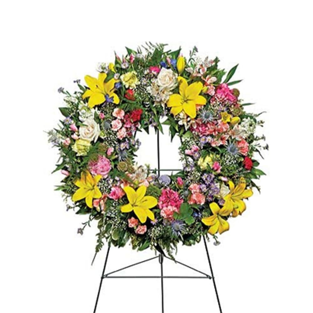 Warm Thoughts Wreath - A bright standing wreath of greenery and fresh flowers in yellow, pink, blue and white will send a message of hope and harmony, and help to celebrate a meaningful life.
