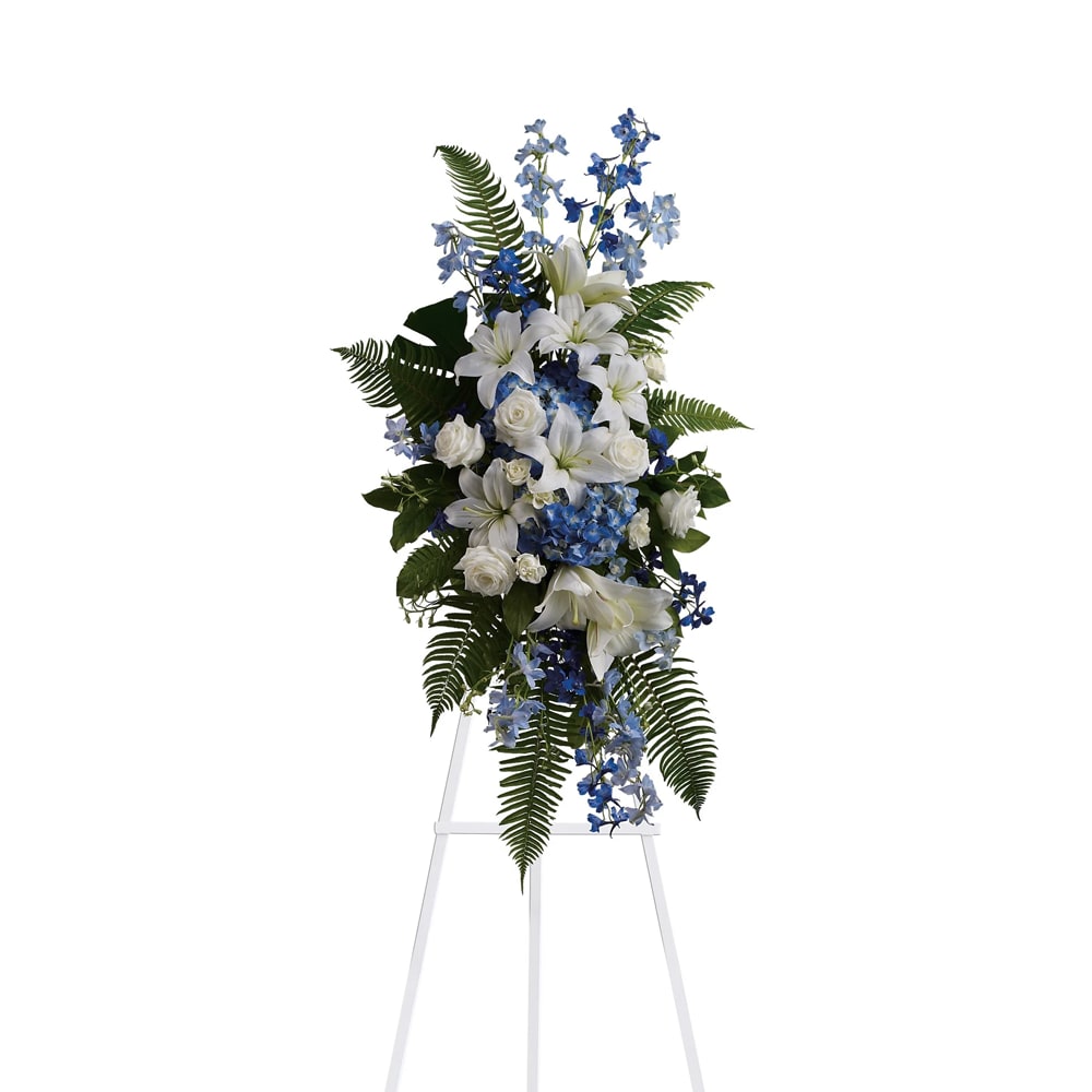 Tall white and blue floral standing spray on a white easel