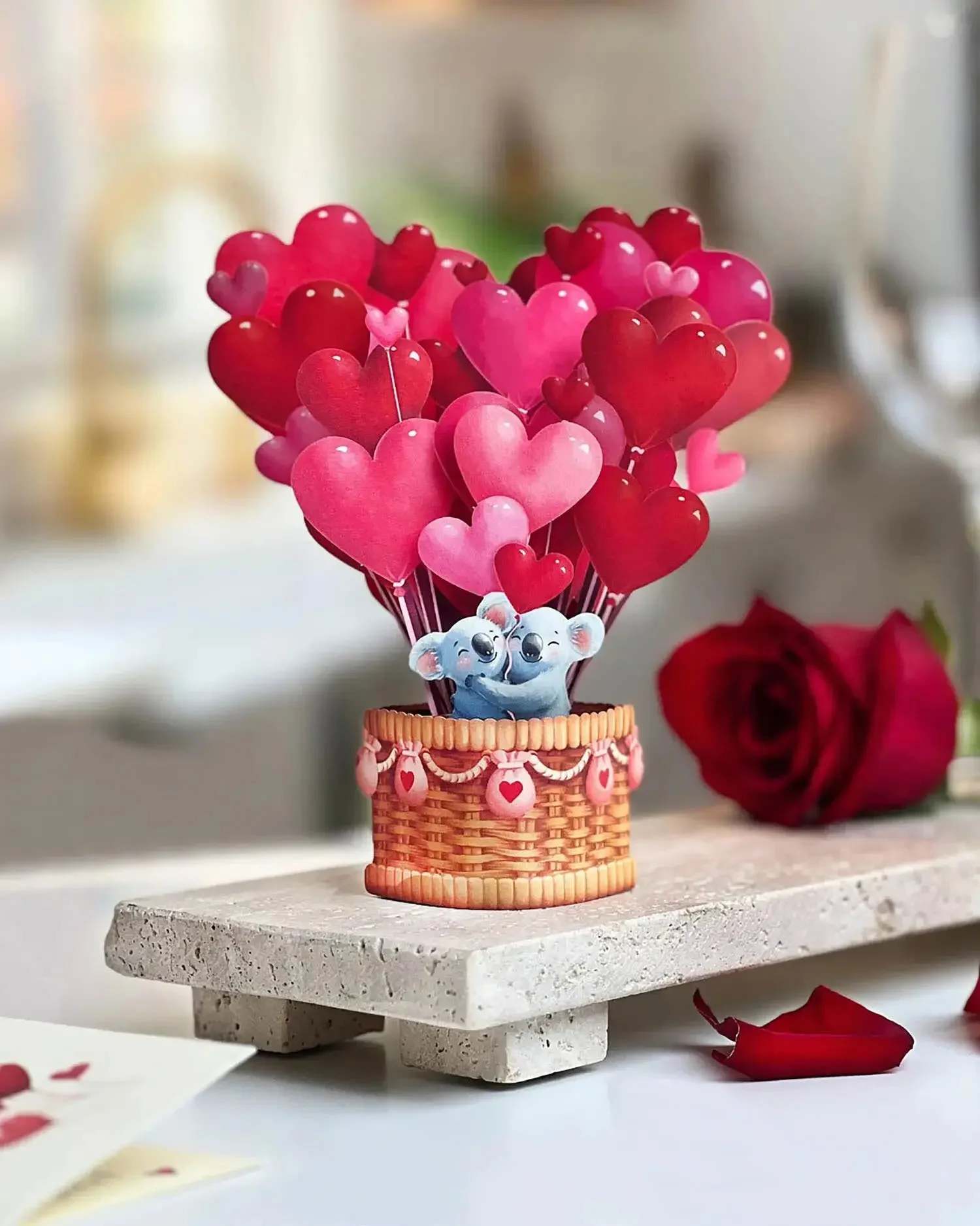Heart-shaped balloons in a basket with a small koala figure