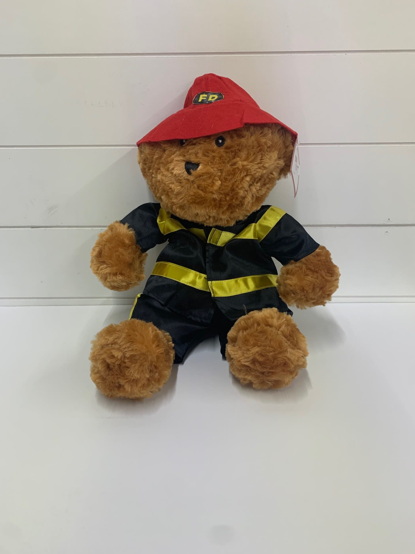 Teddy bear in a red firefighter hat and black uniform
