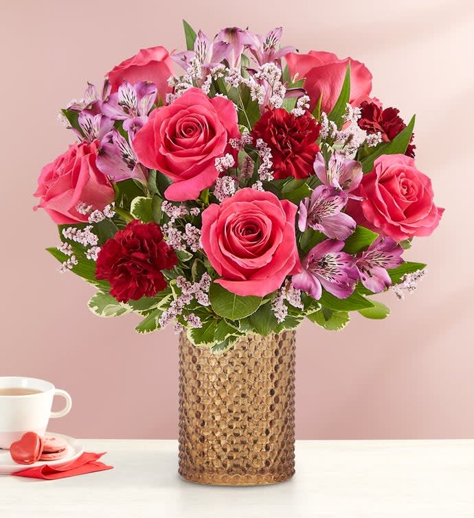 Pink roses and red carnations in a textured vase