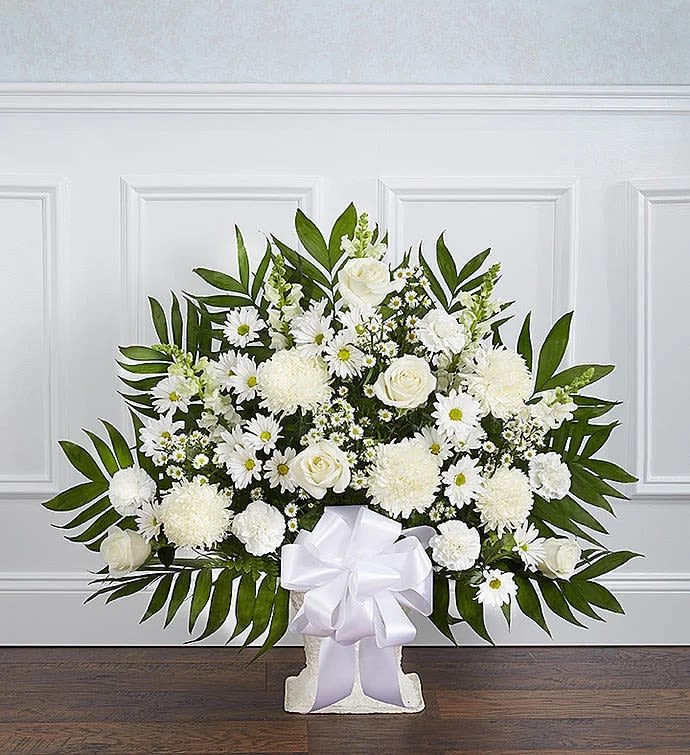 White floral spray with daisies and roses in a white stand with ribbon
