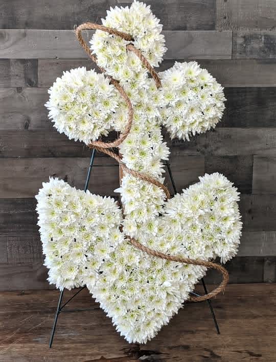 White floral anchor-shaped sympathy arrangement with rope on a stand