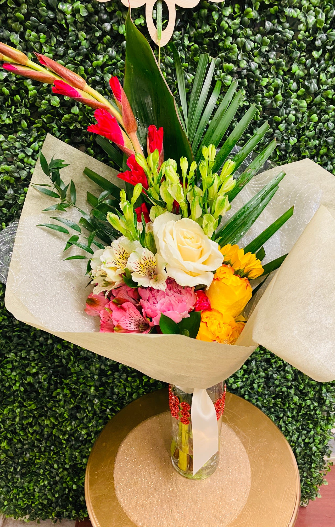 Mixed bouquet with roses, alstroemeria, and bright tropical blooms in a glass vase