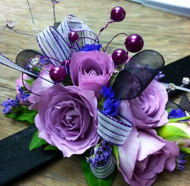 Lavender rose bouquet with purple accents and ribbon loops