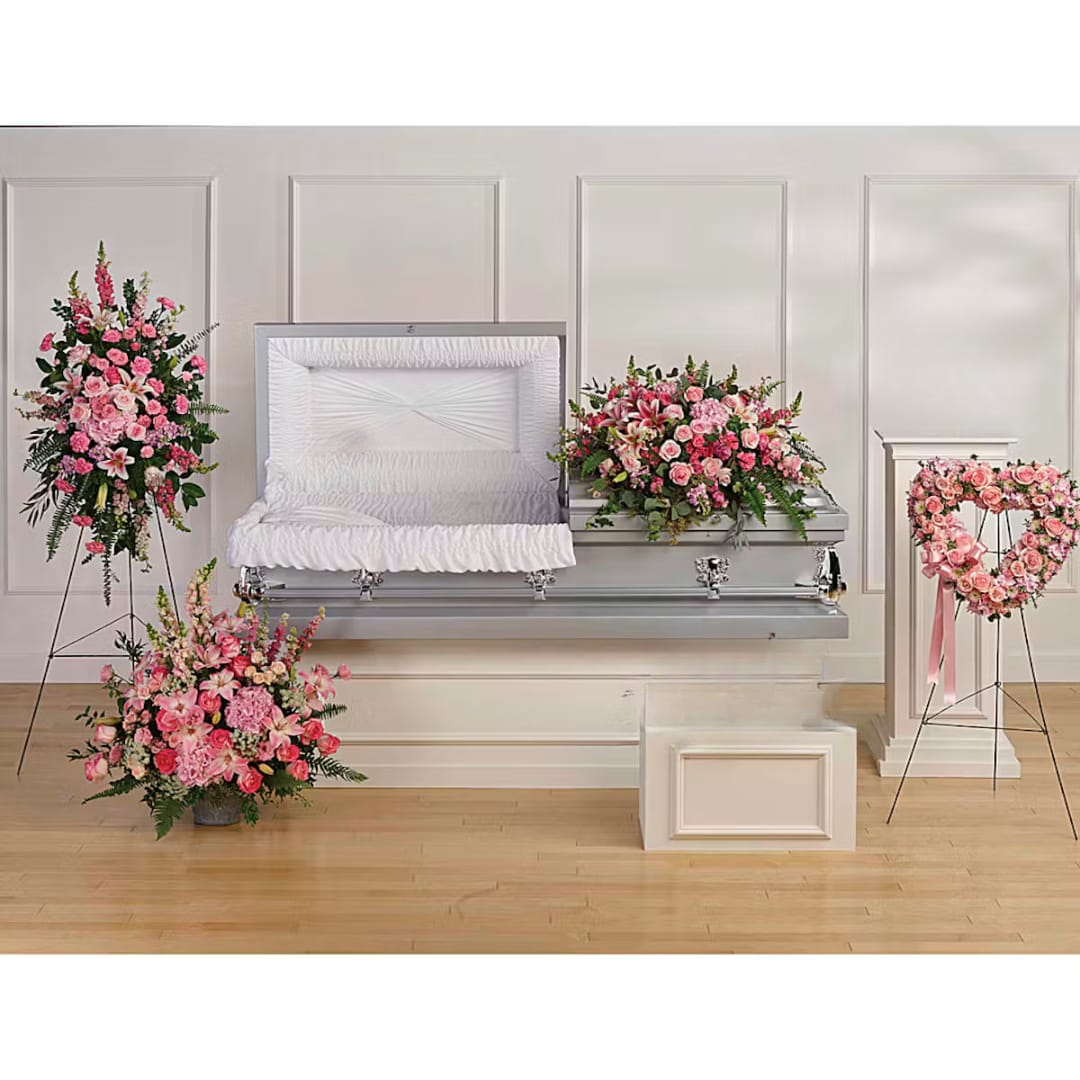 Pink floral funeral casket spray with matching standing arrangements and heart wreath