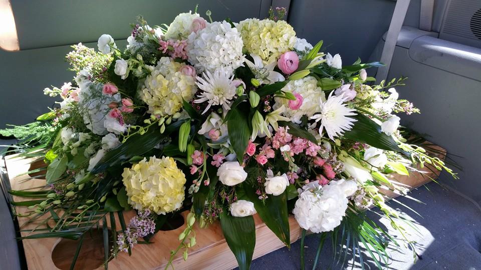Large white and pink floral casket spray with lilies and hydrangeas