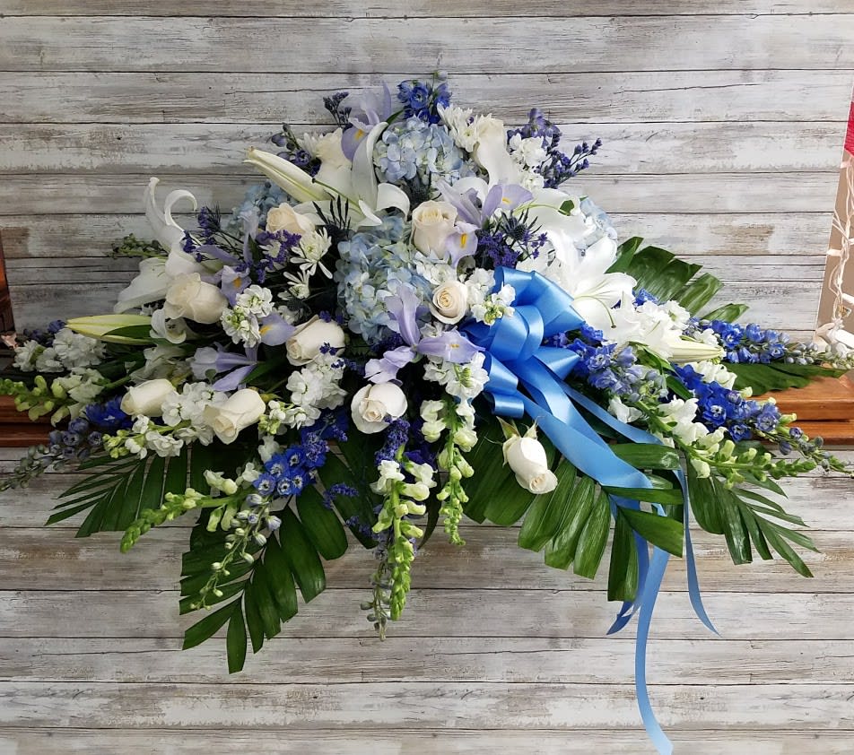 Large white and blue floral spray with a blue ribbon