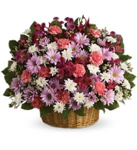 Mixed pink, purple, and white flowers in a wicker basket