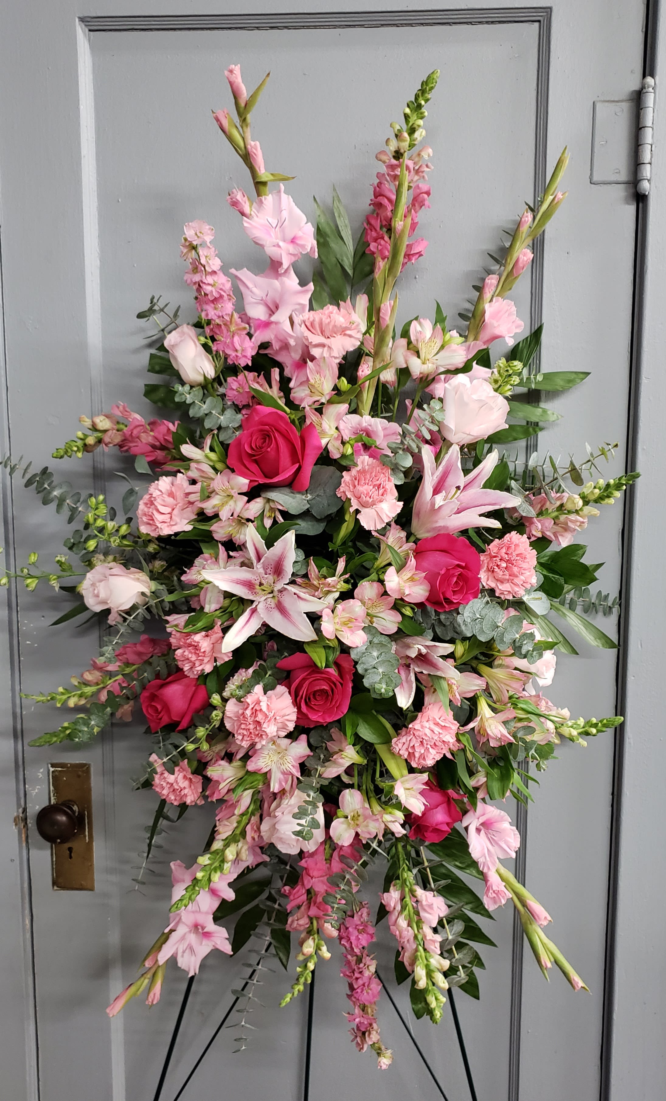 Pink Tribute Spray - With a bounty of lovely pink flowers and simple greens, this pretty spray lets you express your sympathy beautifully. 
