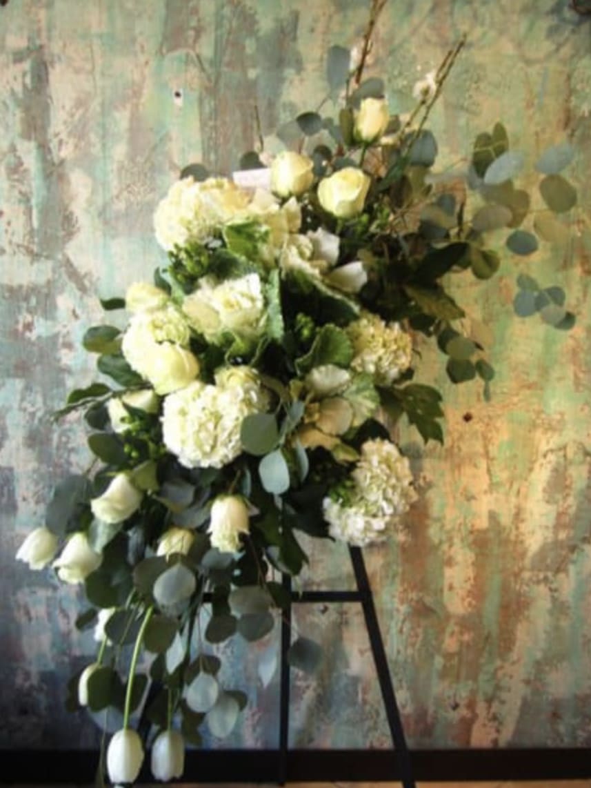 White floral spray with roses and hydrangeas on a stand