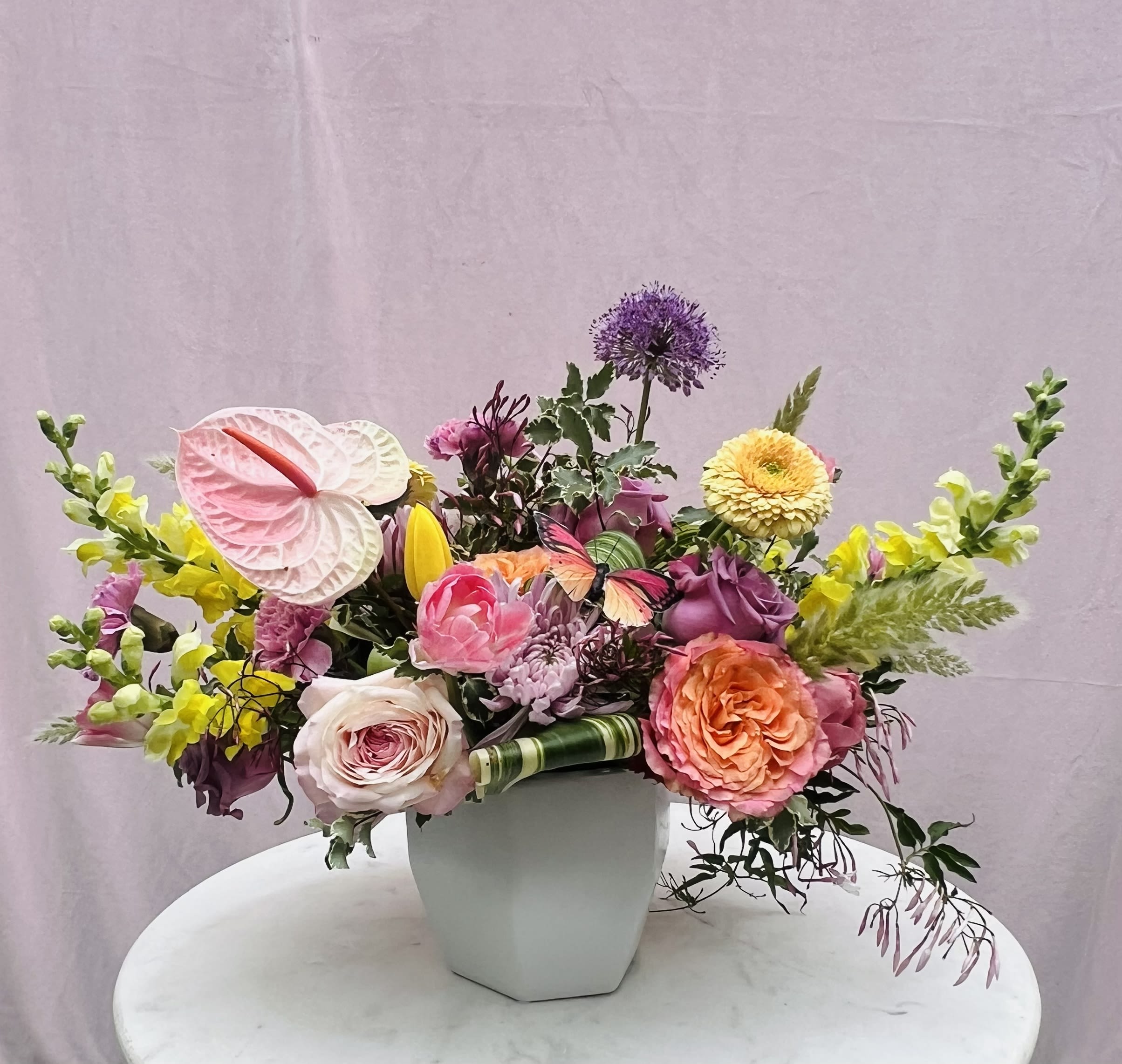 Anne - Soft, sunlit, and full of charm—this cheerful pastel arrangement brings a breath of fresh air to any space. Designed with premium seasonal blooms and lush greenery, it strikes a perfect balance of elegance and warmth.  Each arrangement is thoughtfully handcrafted in a high-end vase, creating a refined, uplifting piece that feels both timeless and modern. The soft color palette and natural movement of the flowers make it an effortless way to brighten a home or send a meaningful gift.  Flowers and greenery may vary due to seasonal availability, but that’s part of the charm! Our creative designers will substitute with the freshest high end product available- some grown in our very own garden!- and create something beautiful.  *Have a special request?* Let us know in the special instructions section during checkout.