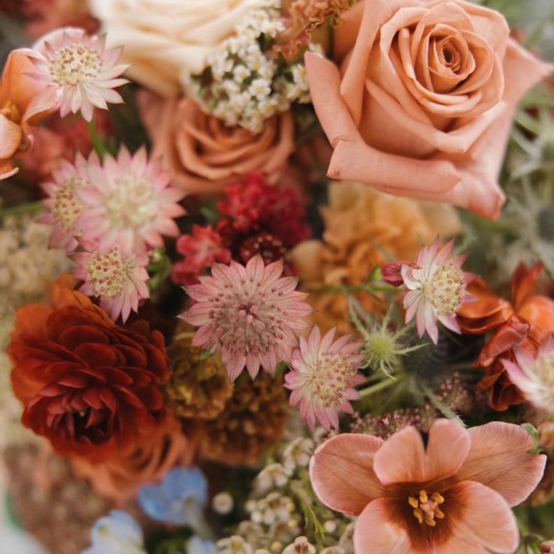 Peach roses and pink star-shaped flowers in a mixed bouquet