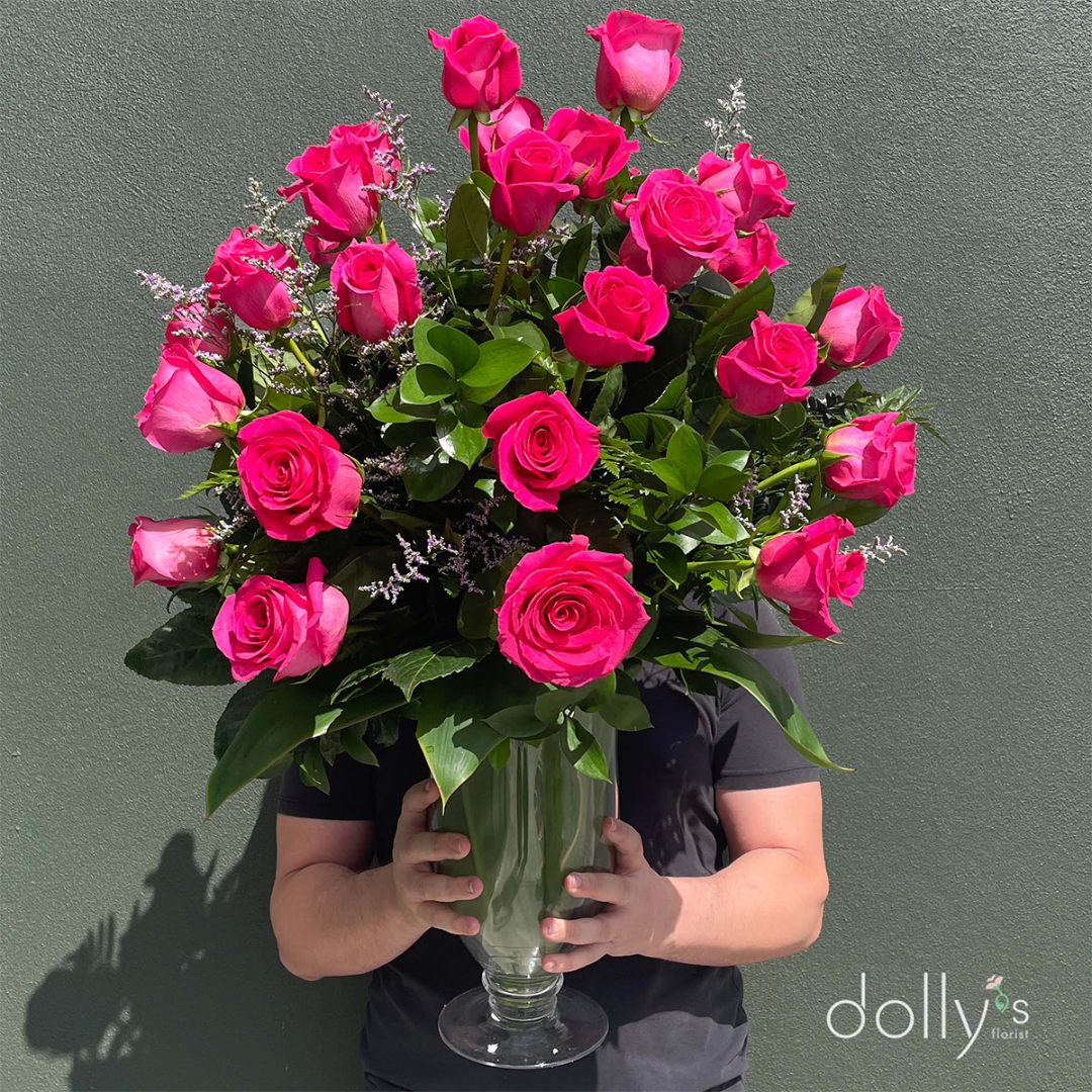 Tall bouquet of hot pink roses in a clear glass vase