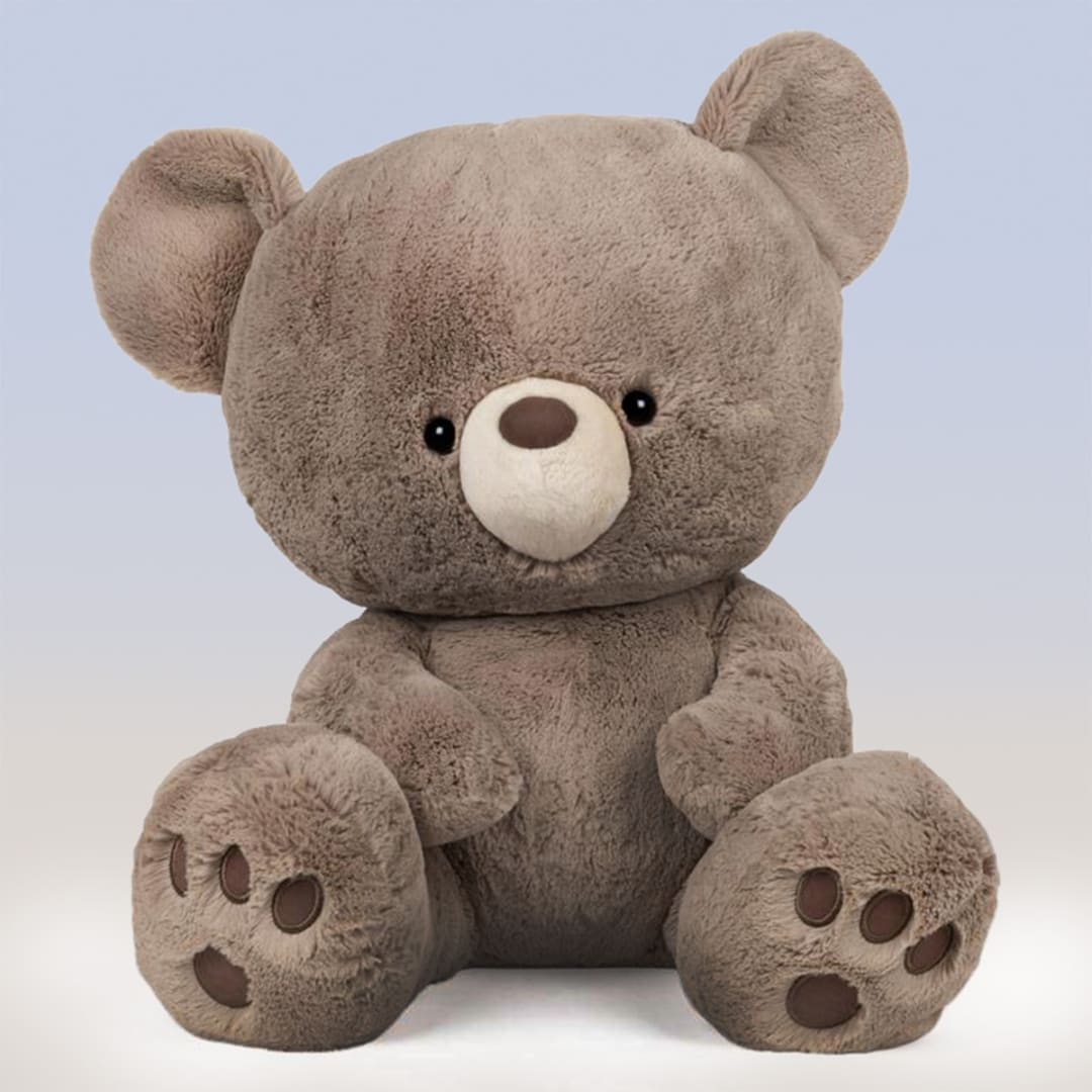Plush teddy bear sitting against a plain background