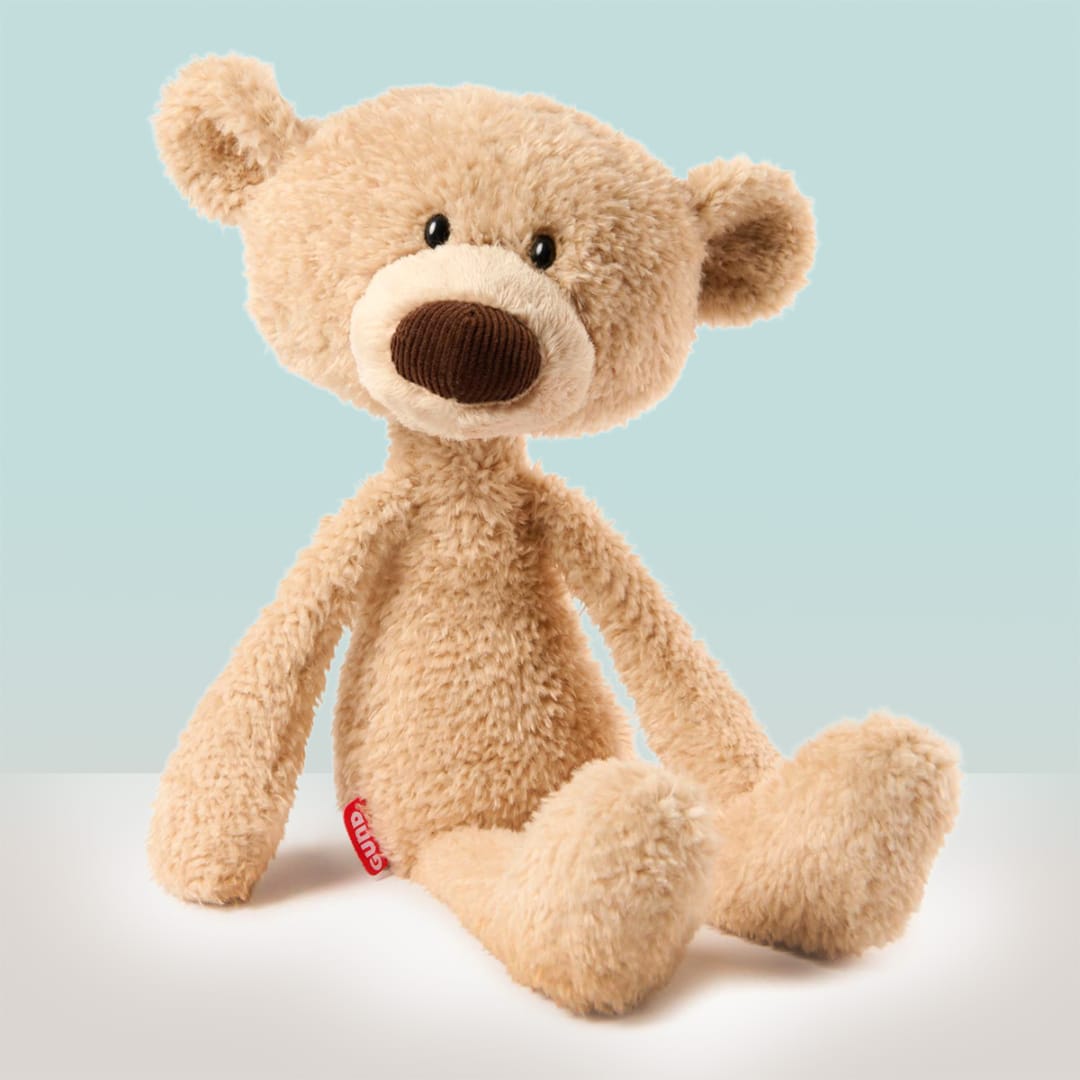 Plush teddy bear sitting against a light blue background