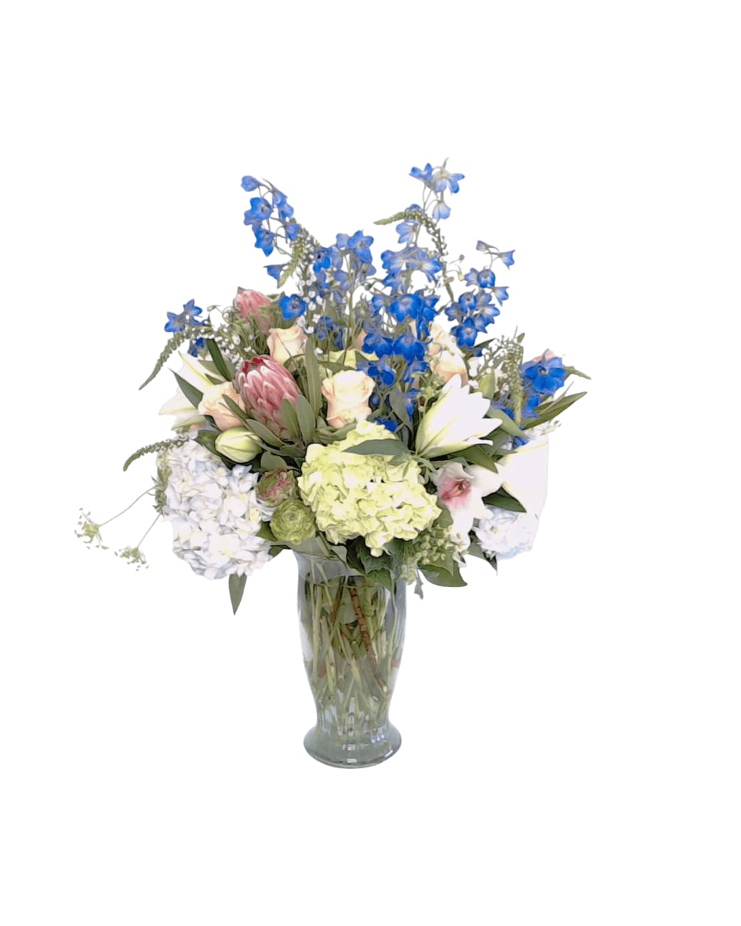 Mixed bouquet of blue and pastel flowers in a clear glass vase