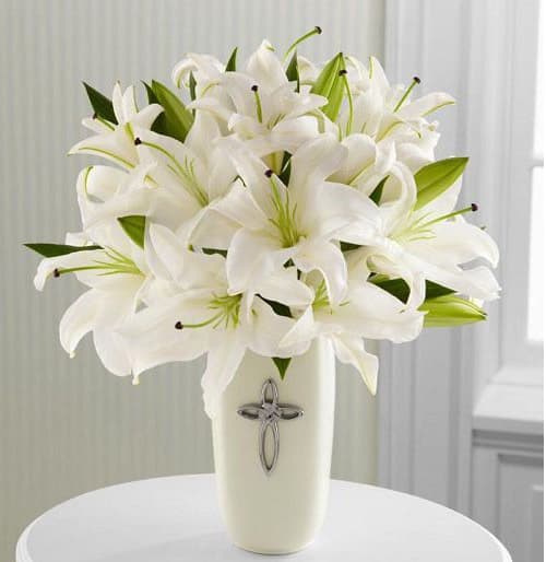 The Faithful Blessings Bouquet - This striking display of pure white lilies will send your heartfelt expressions when words just aren't enough. Arranged in a white ceramic vase and enhanced by a silver-tone cross, this arrangement is perfect for First Communion celebrations, confirmations, sympathy, weddings, or a special anniversary.