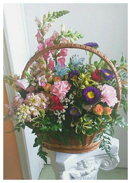 Basket arrangement of mixed pink, purple, and orange flowers