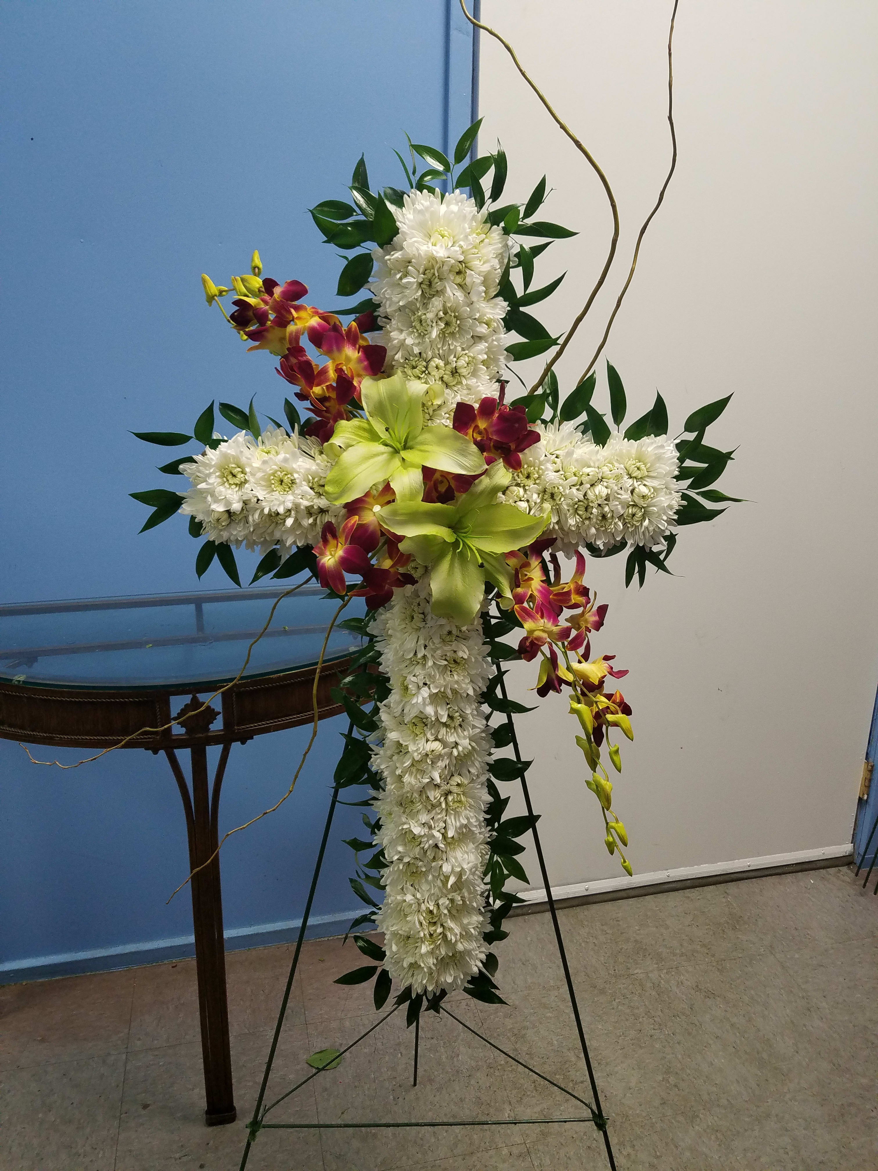 Cross-shaped floral standing spray with white chrysanthemums and green orchids