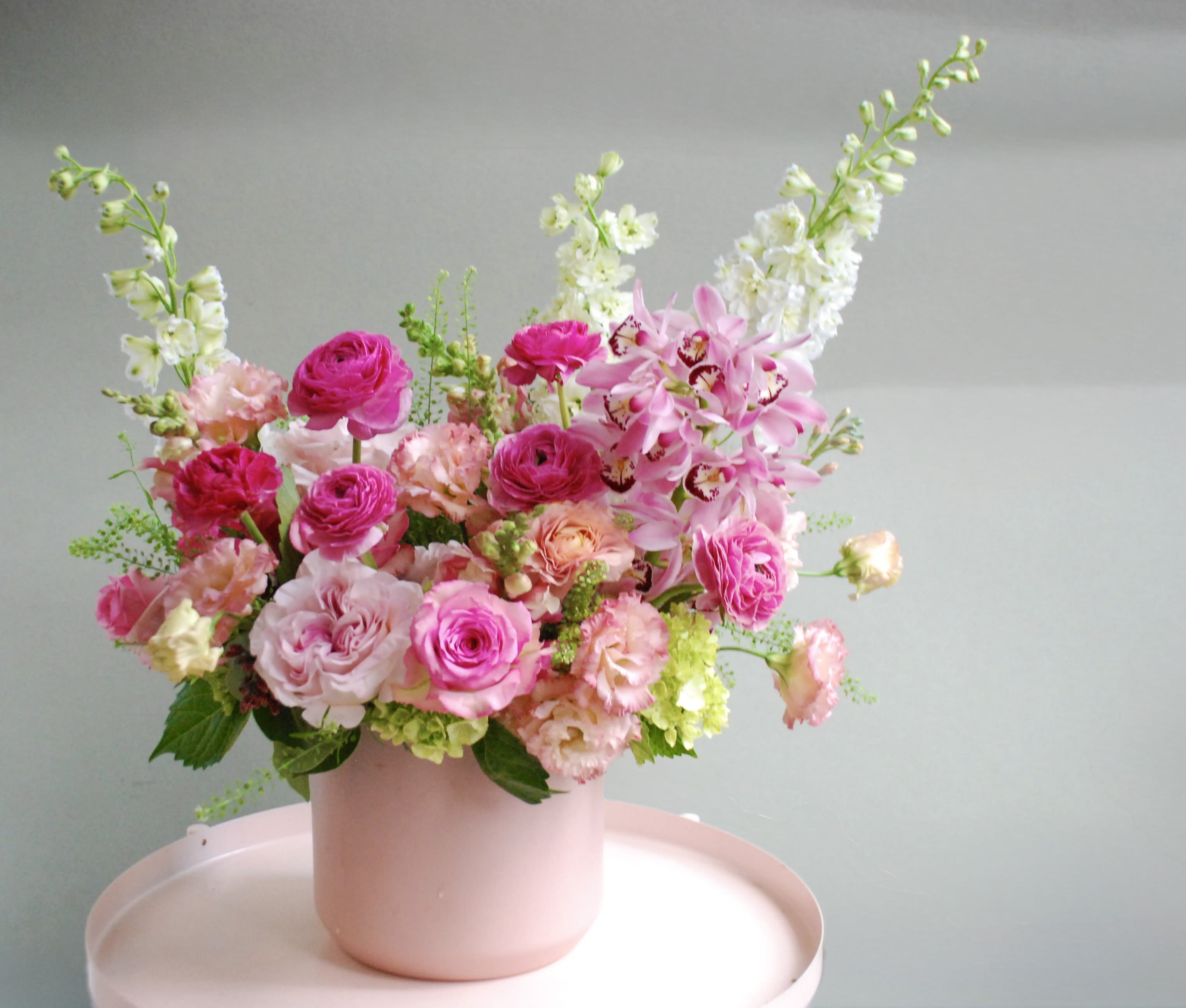 Pink and white floral arrangement in a blush vase