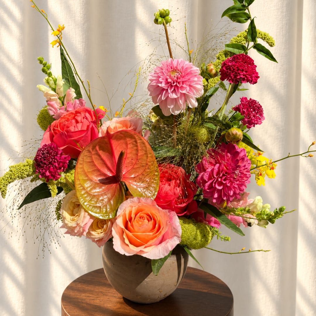 Colorful mixed flower arrangement in a round vase