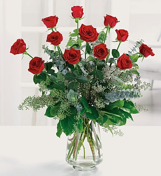 Red roses arranged in a clear glass vase