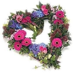 Heart-shaped floral wreath with pink gerberas and blue hydrangeas