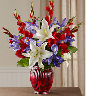 The FTD® Loyal Heart™ Bouquet - Celebrate a life dedicated to the love of country with a vibrant bouquet of red, white and blue blossoms beautifully hand-arranged by an FTD local artisan florist. This bright and beautiful tribute evokes loving memories of the deceased's devotion to the nation−in the armed forces, as a government worker or as a public spirited patriot. Its red roses, white gladiolus and Oriental lilies, and blue irises beautifully reflect the colors of their beloved flag and are arranged in a classic vase of ruby red glass. It is sure to be long remembered at a wake, funeral service or for offering your condolences at the home of grieving family and friends.  GOOD arrangement includes 17 stems. Approximately 21"H x 17"W.   BETTER arrangement includes 22 stems. Approximately 23"H x 19"W.   BEST arrangement includes 27 stems. Approximately 24"H x 20"W. Your purchase includes a complimentary personalized gift message.