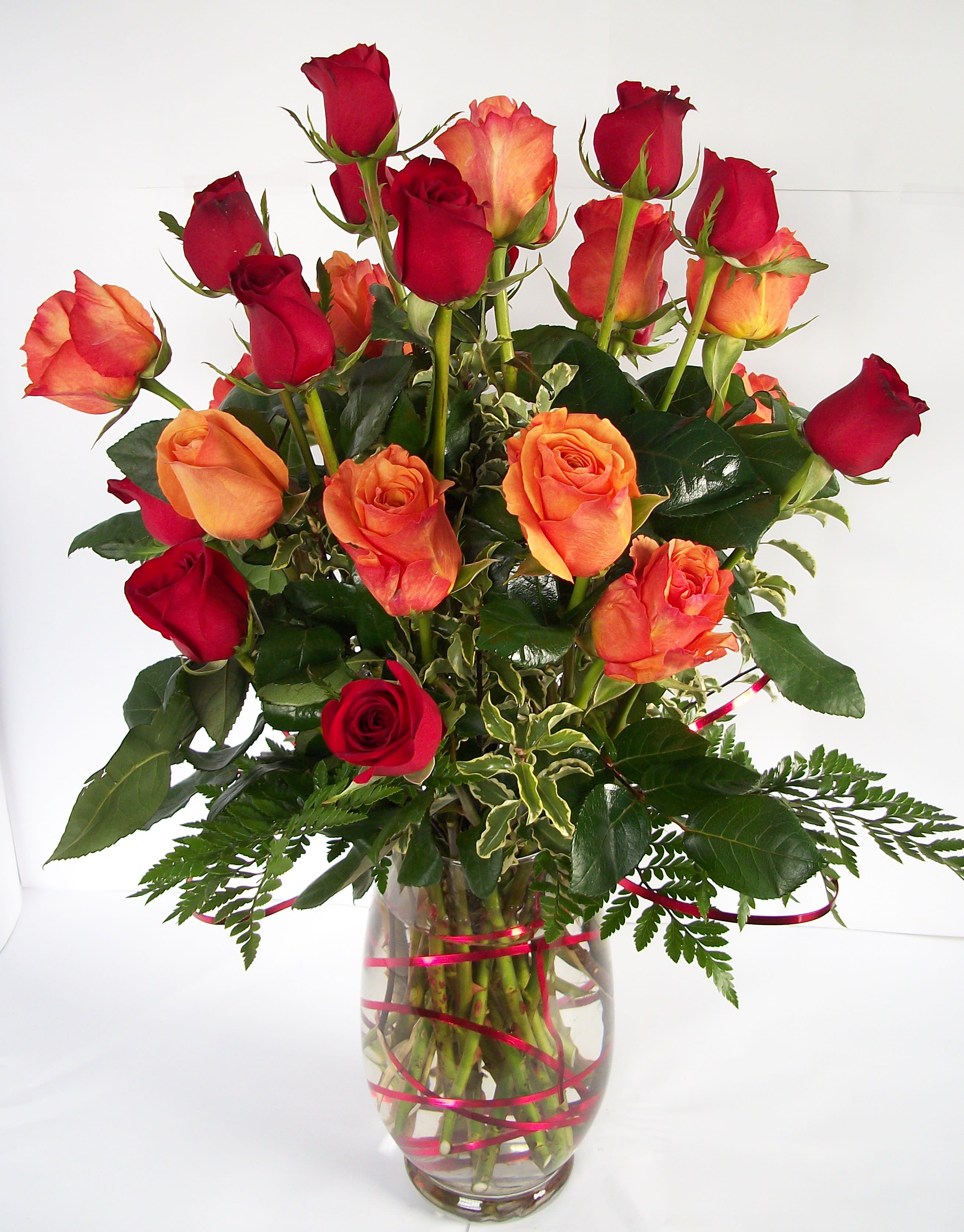Bouquet of red and orange roses in a clear glass vase