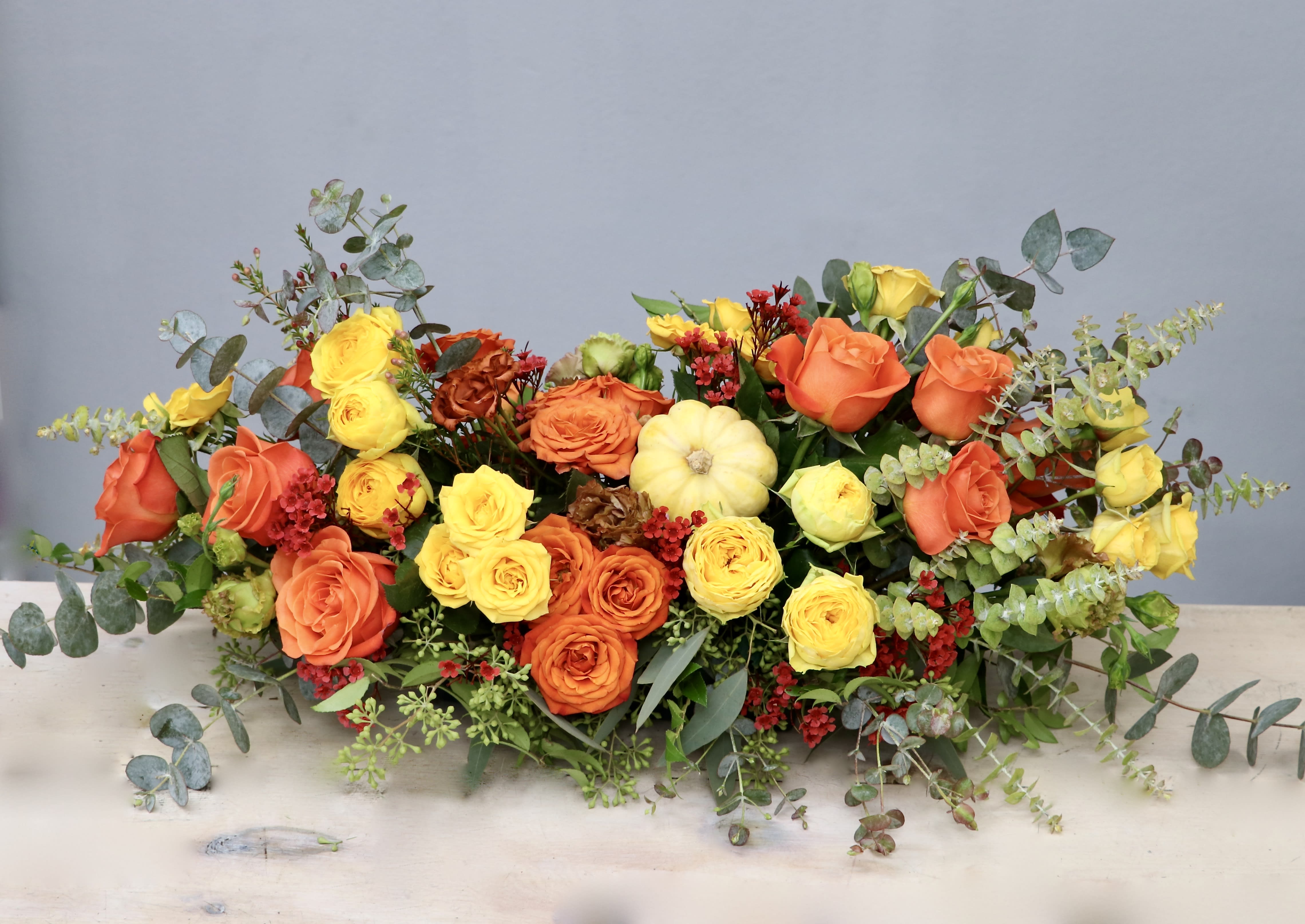 Thankful Table - West Hollywood Flowers  - Just in time for the holidays, this beautiful table top centerpiece is just what your Thanksgiving feast is missing. Packed full of vibrant roses, it sits low and long on the table, measuring approximately 6-8 inches tall and 12-14 inches wide in the standard size. 