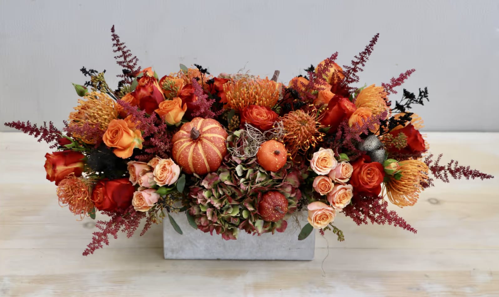 Spice of Fall - WeHo - Just in time for the holiday season, don't miss out on our latest autumnal arrangement! Filled with orange roses, antique hydrangeas, and mixed with seasonal greens this makes for the perfect gift to brighten anyone's table. The displayed arrangement is shown in the standard size, 10-12 inches tall and wide.